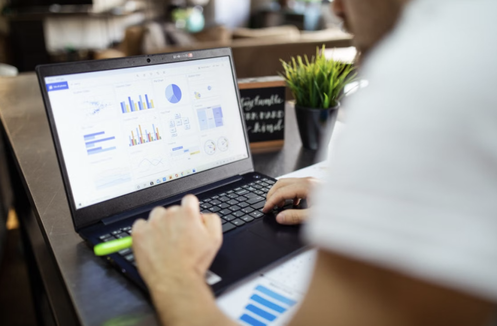 Digital marketer sat at their desk on a laptop analysing metrics on the screen