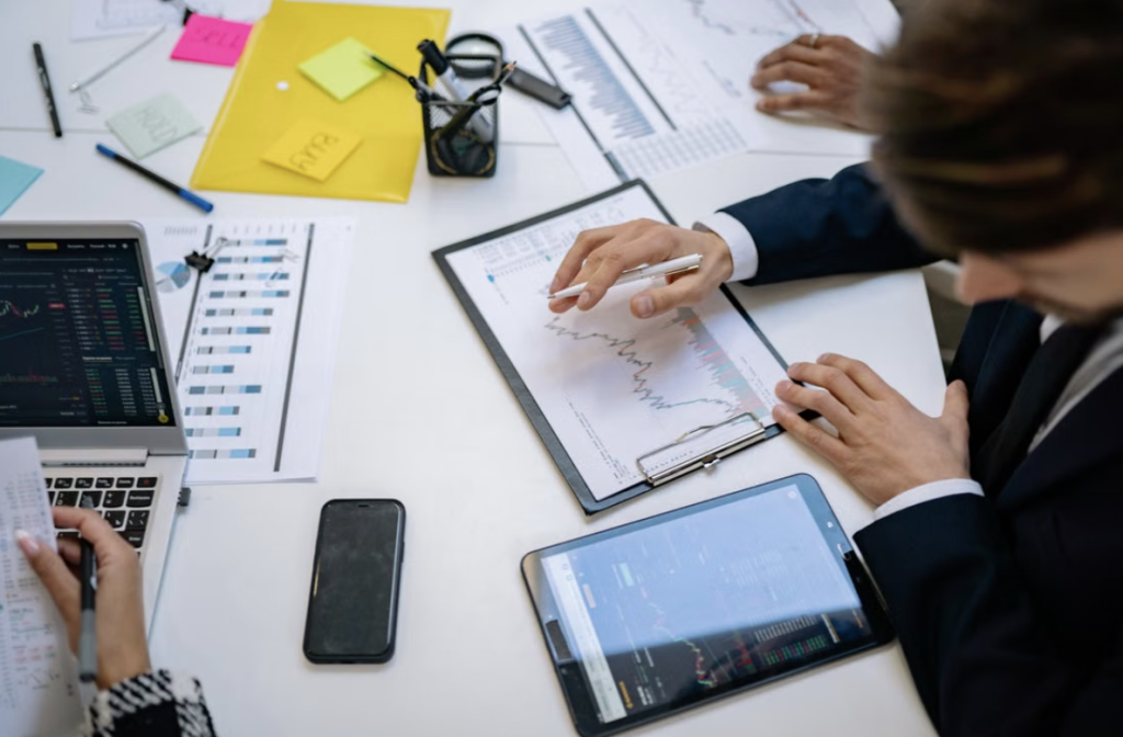 Office workers sat working together at a desk analysing data